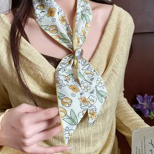 Detail view of an elegant floral print silk scarf necklace with wood flower clasp