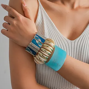 Dettaglio di braccialetti elastici in smalto e un bracciale in resina marmorea