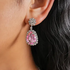 Close-up of elegant pink teardrop crystal earrings with clear rhinestone pavé setting