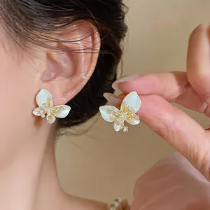 Detailed close-up of elegant French style butterfly stud earrings with pearls.