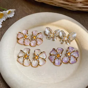 Close-up of elegant French-style floral and butterfly earrings with pearl-like textures