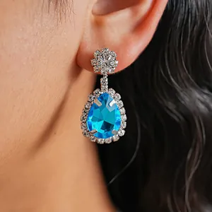 Close-up of retro palace style teardrop earring with blue crystal and rhinestones