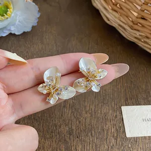 Detail of French style butterfly earrings with pearls and crystals on gold plating
