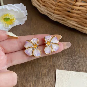 Detailed macro view of French pearl flower earrings with lavender gradient petals.