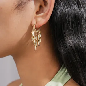 Close-up macro detail of elegant gold-tone wheat leaf tassel drop hoop earrings