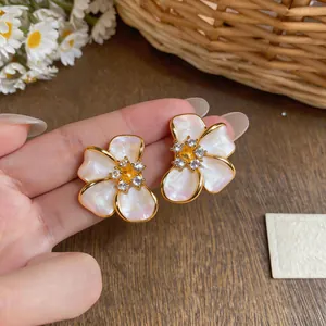 Macro detail of elegant French style pearl flower stud earrings with gold plating