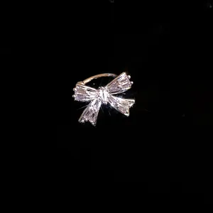 Dettaglio ravvicinato di un ear cuff a fiocco in zircone con elegante finitura argento.