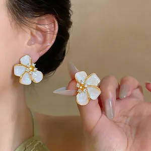 Close-up showing the pearlescent finish and crystal detail of the flower earring