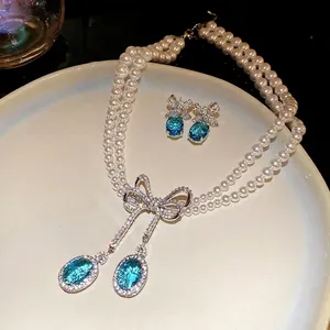 Élégant ensemble de collier et boucles d'oreilles en perles avec nœud en zircon bleu
