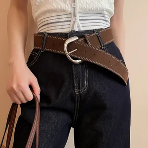 Brown leather belt with white zigzag stitching and a large silver oval buckle detail.