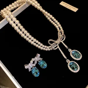 Parure élégante collier perles deux rangs et boucles d'oreilles nœuds zircon cristaux