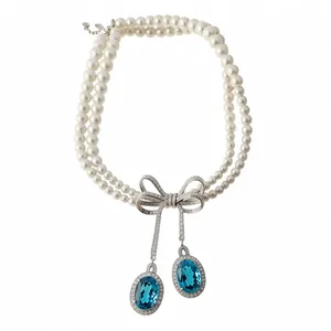 Élégant collier de perles à deux rangs avec nœud en zircone et pierres bleues