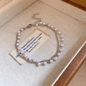 Close-up of elegant double-layer bracelet with pearls and silver metal chain