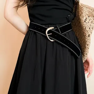 Detail shot of black leather belt with silver horseshoe buckle and white stitching.