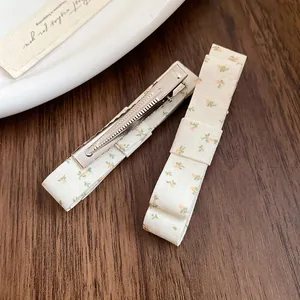 Close-up of sweet floral fabric bow hair clips featuring a high-quality metal duckbill clip