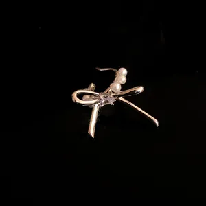 Primo piano di un elegante ear cuff a fiocco in argento con zirconi e perle bianche