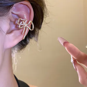 Primo piano di un ear cuff a forma di fiocco con zirconi, perfetto per un look di classe.