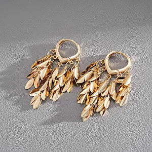 Detailed close-up of golden wheat leaf tassel huggie earrings in vintage style