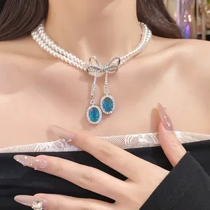 Vue détaillée d'un collier de perles double épaisseur avec nœud en cristal bleu