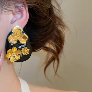 Detail view of a vintage gold flower resin stud earring in New Chinese style