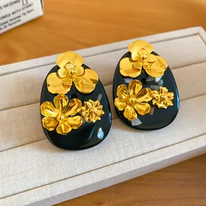 Close-up detail of vintage golden floral patterns on black resin stud earrings for women