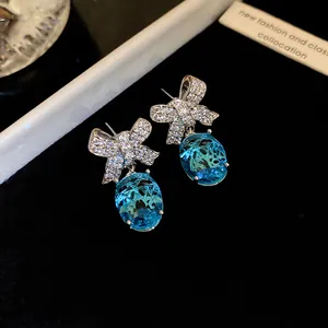 Vue rapprochée d'élégantes boucles d'oreilles nœud vintage avec cristaux bleus