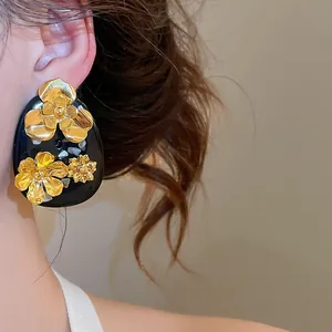 Detailed view of elegant retro golden flower resin stud earrings in New Chinese style