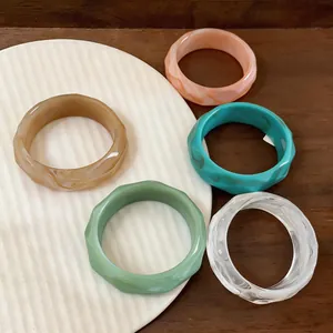 Detail view of colorful faceted acrylic bangles with marble-like textures