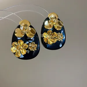 Detailed view of vintage gold flower resin earrings with intricate petal textures
