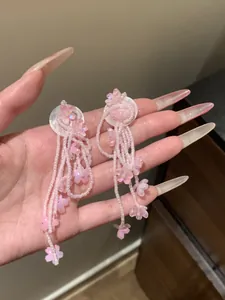 Close-up of pink beaded floral tassel earrings with silver needles for a sweet look.
