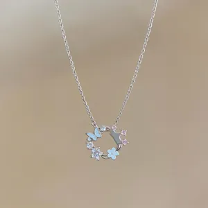 Detailed view of an elegant butterfly and flower necklace pendant with zircon accents