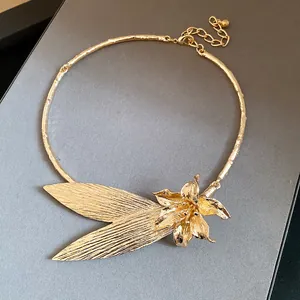 Detailed macro view of a vintage gold metallic flower and leaf choker style necklace