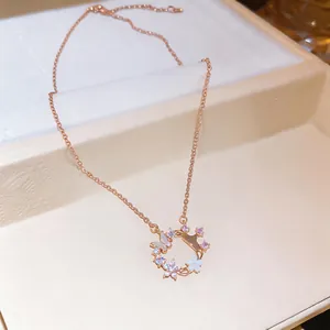 Close-up of rose gold necklace featuring zircon butterfly and shell flower pendant