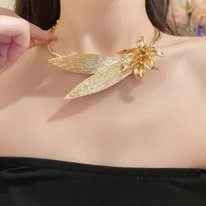 Detailed view of an elegant vintage gold metal flower and leaf choker necklace.