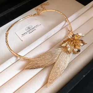 Detailed view of vintage gold metal necklace featuring large flower and leaf motifs