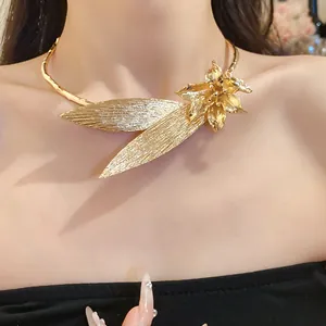 Detailed view of elegant vintage gold metal flower and leaf collar necklace on model