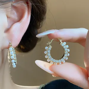 Detailansicht eleganter Creolen im französischen Stil mit Perlen und glänzenden Zirkonia