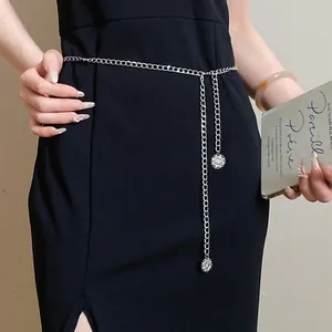 Detailed macro view of a silver minimalist circular metal chain belt worn over a black dress