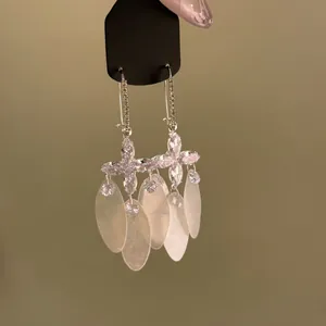 Detail view showing sparkly marquise zircon flowers and frosted white shell tassel drops