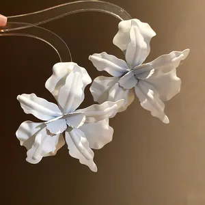 Close-up of matte white flower stud earrings with elegant layered petals