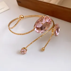 Close-up of gold metal arm cuff with pink oval rhinestones showing intricate detail
