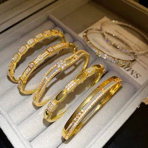 Detail view of gold plated bangles with sparkling cubic zirconia stones in a gray box