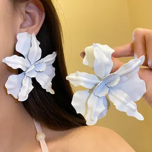 Detailed view of oversized white flower earrings with matte finish petals.