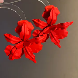 Detailed macro view of matte red spray-painted flower earrings with lifelike petal texture