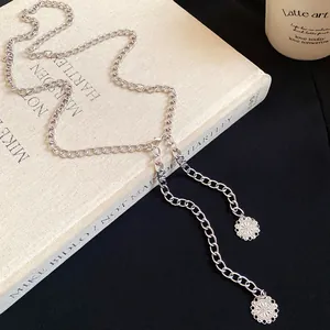 Detailed view of a silver chain waist belt featuring elegant carved flower pendants.