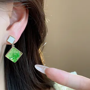 Detailansicht eleganter, 14k vergoldeter geometrischer Ohrringe mit grünem Glas.