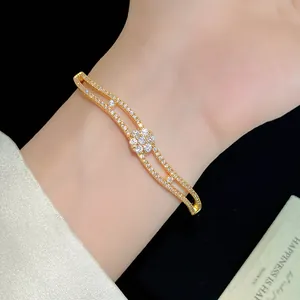 Close-up detail of a double-layered 18K gold plated bracelet with a zircon flower