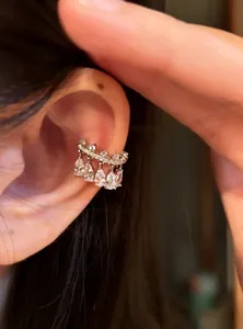 Detail view of a sparkling silver-tone zircon teardrop ear cuff worn on a model's ear