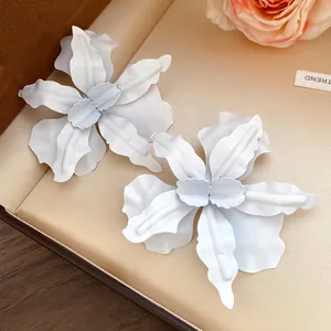 Macro view of white spray-painted flower earrings with a matte finish on jewelry box