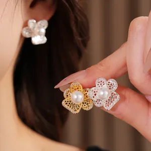 Nahaufnahme von Hohlblumen-Perlenohrsteckern mit Zirkon-Inlay für einen eleganten Look.